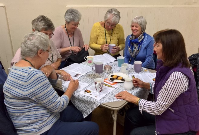 WI members enjoying a group with tea and biscuits